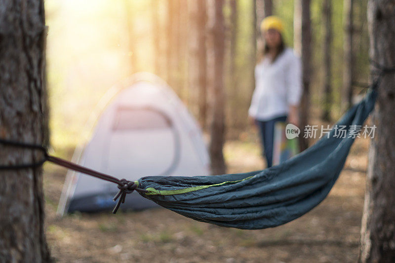 懒惰的下午的户外活动。年轻女子旅游露营在自然与一个吊床。