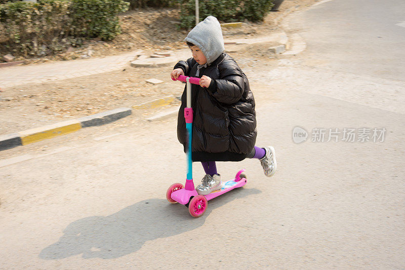 一个小女孩在玩滑板车