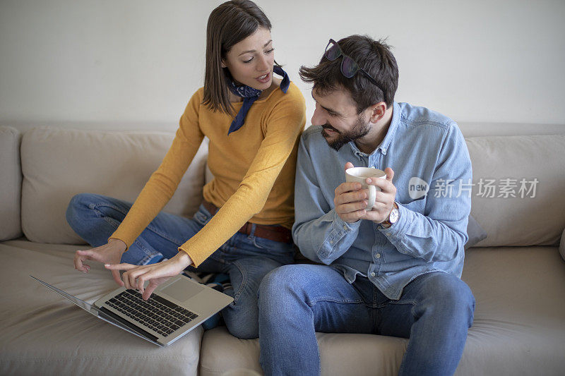 年轻夫妇在客厅里用一台电脑