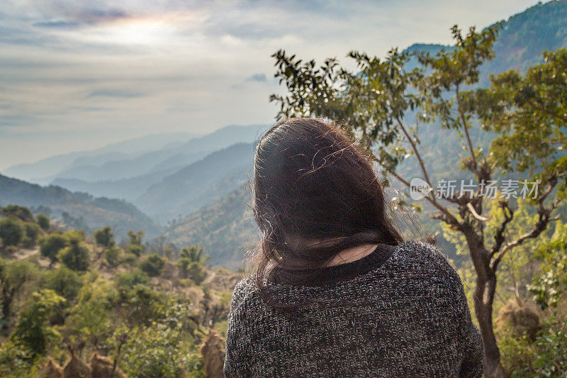 《背谷背山坐在悬崖上的女人，日出》的后视图