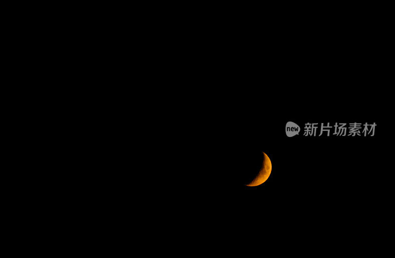 美国俄勒冈州黑色夜空中的橙色新月