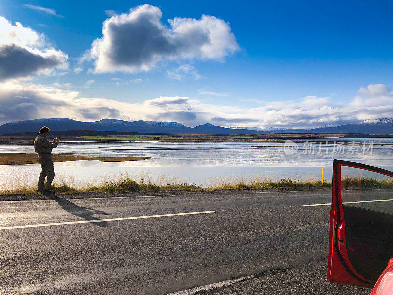 冰岛公路之旅:男子在路边拍摄峡湾(Skagafjordur)