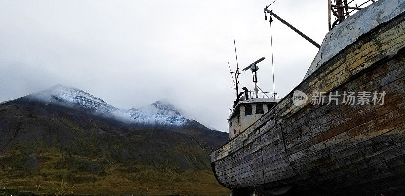 Siglufjörður，冰岛:古老的渔船，雪山