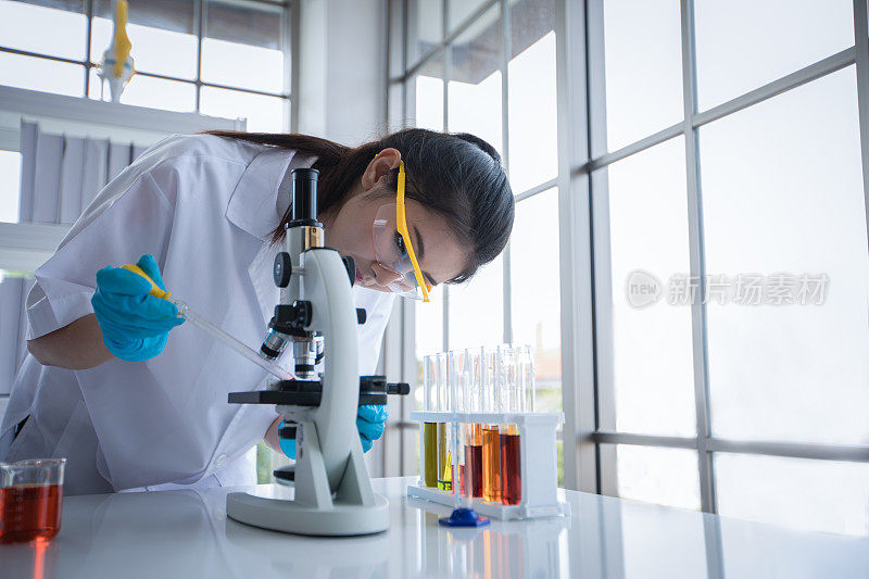 医学研究和科学家们正在实验室中使用显微镜、药片、试管、微管和分析结果。