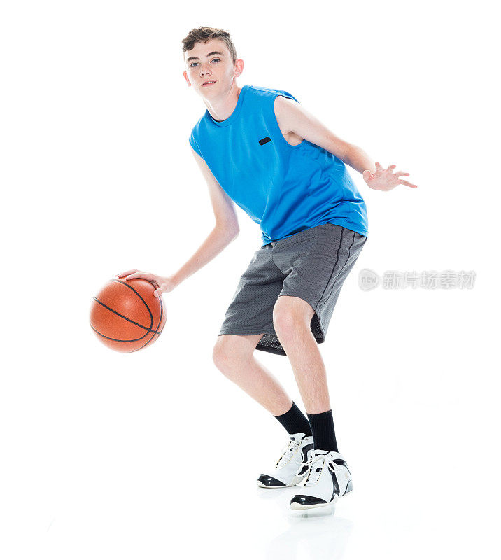 白人年轻男子篮球运动员在白人背景前，拿着篮球和使用运动球