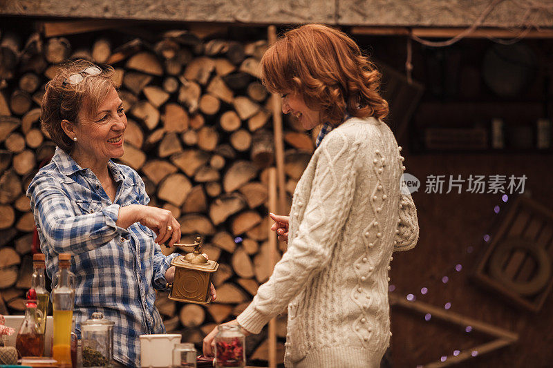 一位年长的母亲和一位中年妇女在一起做菜的时候聊天