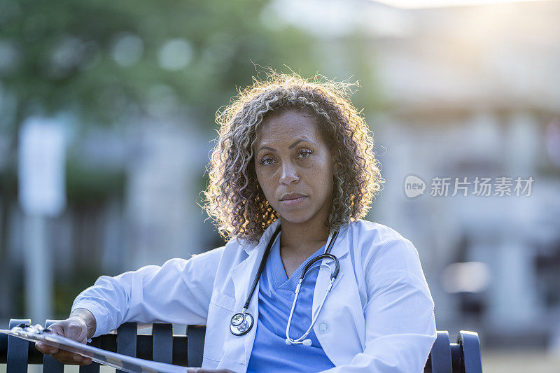 一位非裔美国医生坐在长凳上