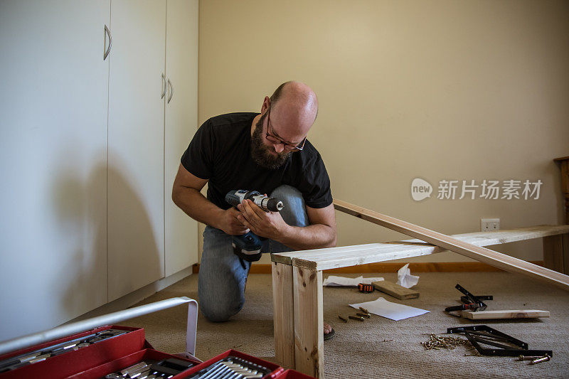男人努力在家里建造一个木工项目