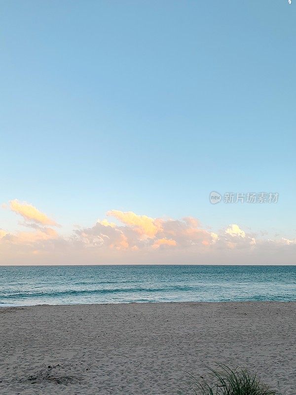 多云的粉红色海滩日落在棕榈滩，佛罗里达