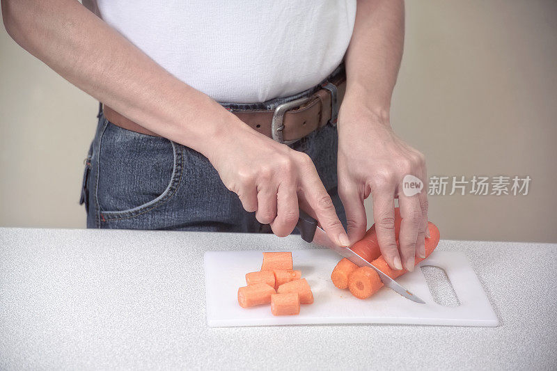 年轻的成年妇女正在切胡萝卜