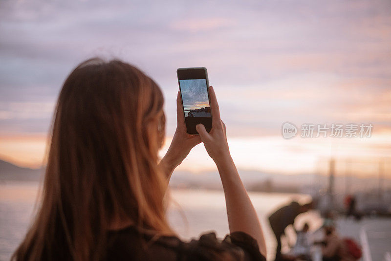 一名年轻女子正在拍摄日落