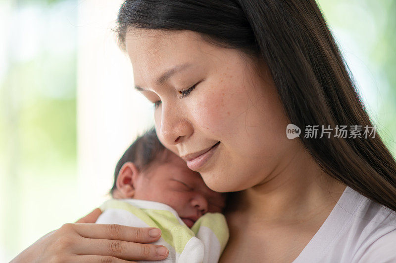 母亲偎依着刚出生的婴儿