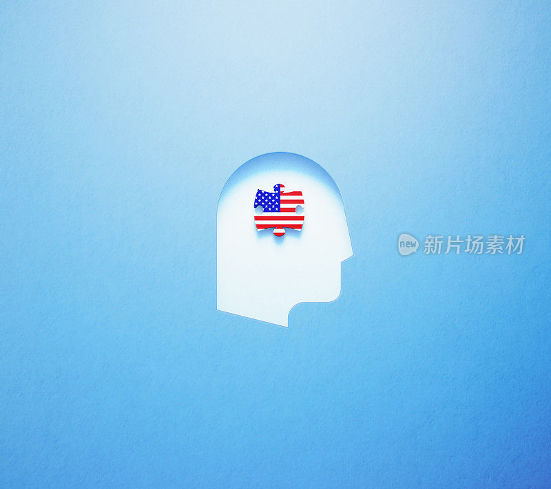 英语学习和说概念-拼图块纹理与美国国旗坐在里面在蓝色的背景上剪出的人头形状