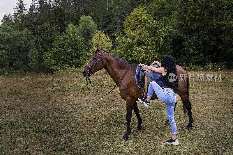 一个女牛仔骑着她的马绕着牧场转