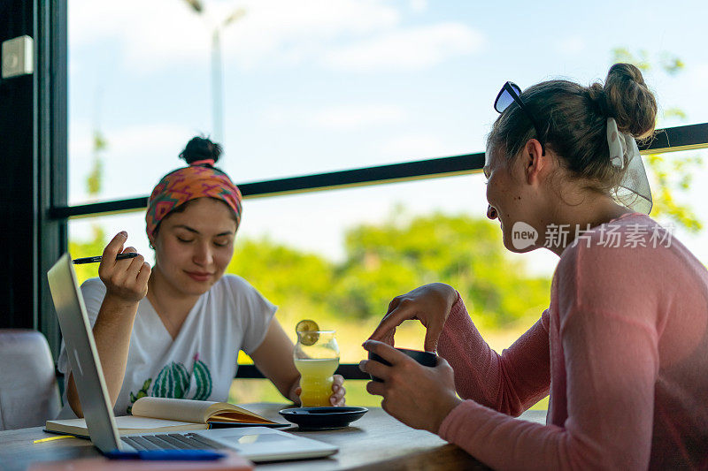 两个年轻女人和她的朋友在咖啡馆里开会