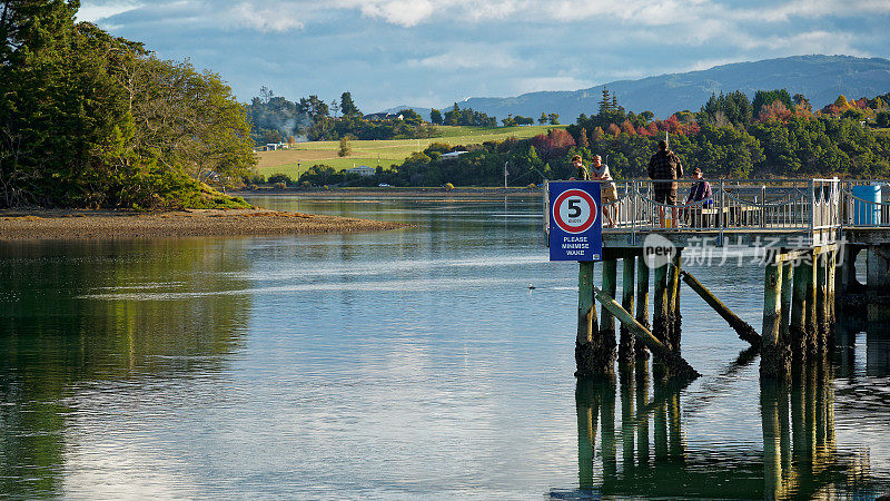 新西兰莫图埃卡港，人们在专门建造的钓鱼平台或码头上钓鱼。