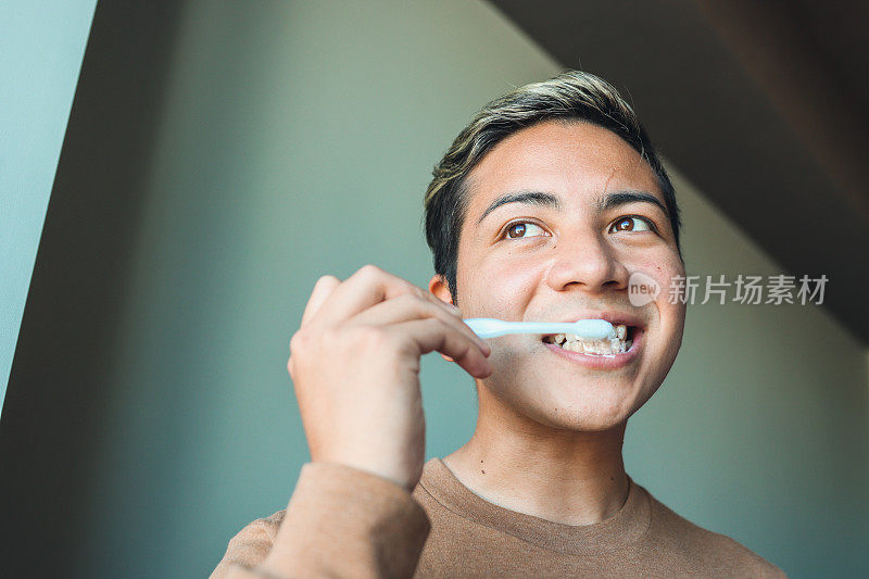 年轻的拉丁男子对着镜子刷牙