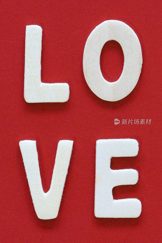 自制DIY简单的情人节卡片设计的图像，红色背景上剪出白色字母，手工浪漫的问候卡，爱的信息