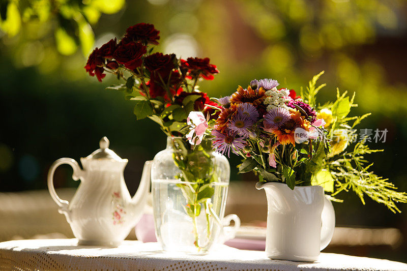 桌上放着花的花瓶，作为下午茶的装饰