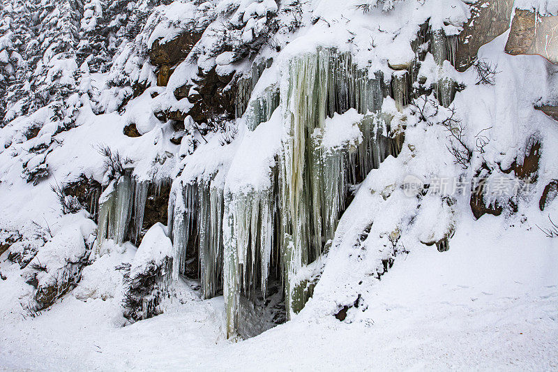 冰柱悬挂在积雪覆盖的山上的冬季景象