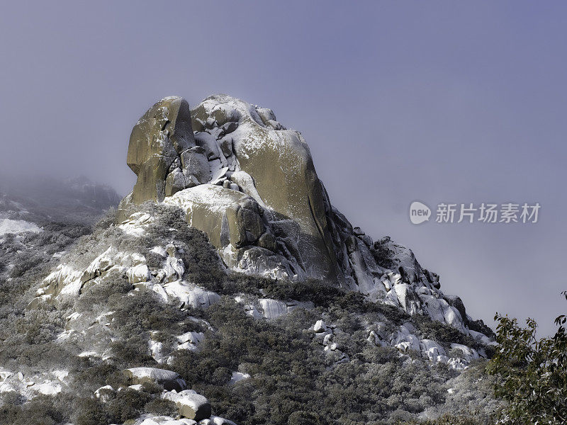 壮观的岩石被雪和雾覆盖