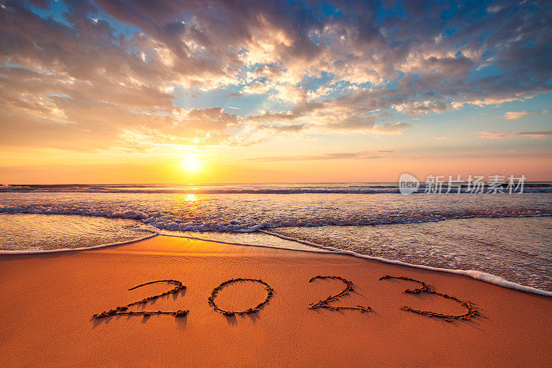 2023年新年快乐，海洋日出沙滩上的沙概念