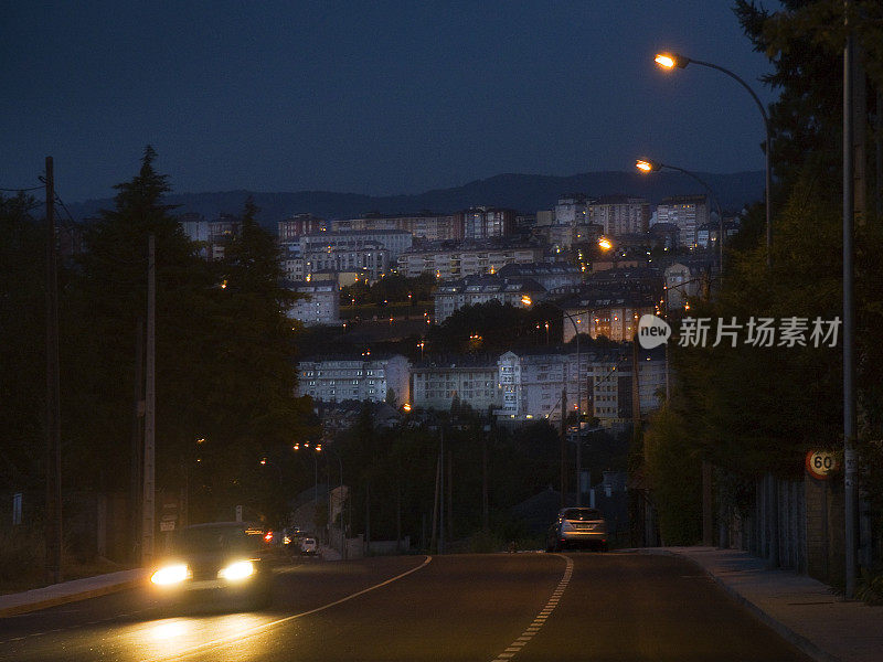 卢戈的街景，汽车前灯，背景是城镇景观。