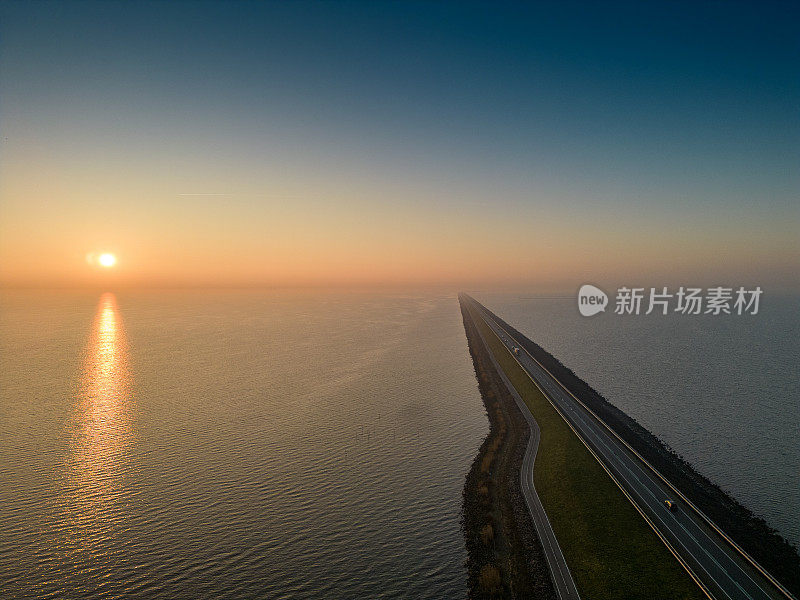 荷兰:黎明时分，荷兰IJsselmeer河26公里长的堤坝。