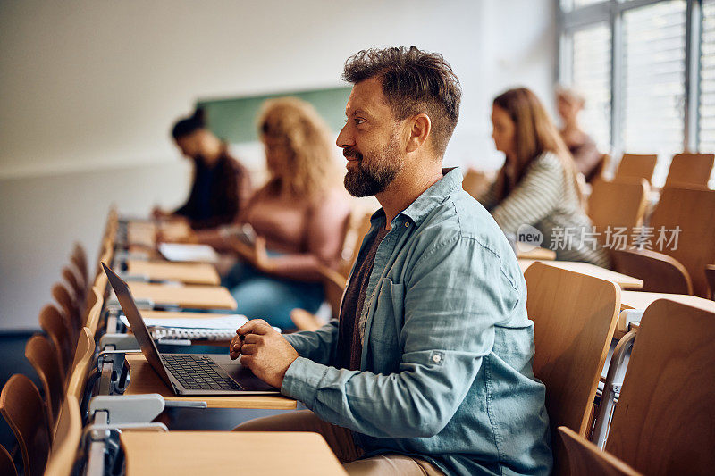 成熟的学生使用笔记本电脑在大学参加讲座。