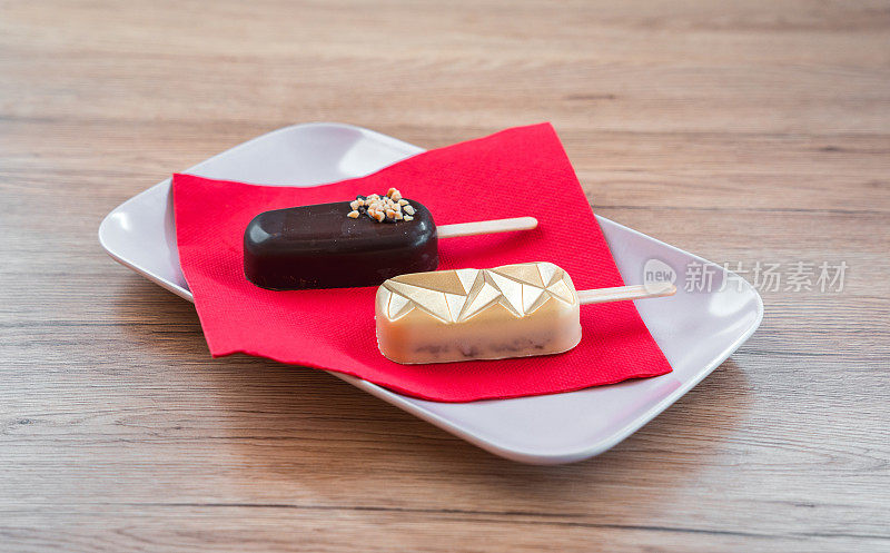 长方形的棒棒糖蛋糕装在陶瓷盘上，配上红色餐巾