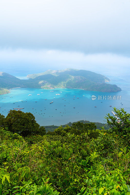 越南孔岛本丹港，湛蓝的大海，蓝天山和五颜六色的船只。