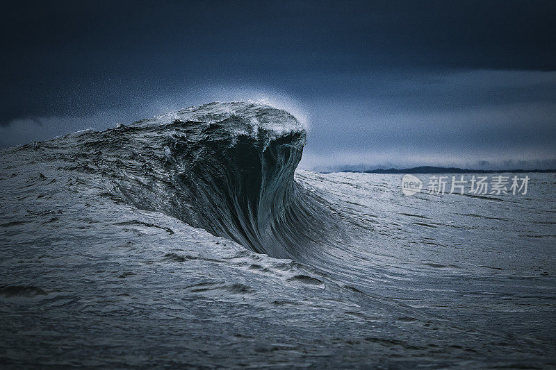 强大的海浪形成在浅礁与暴风雨的天空