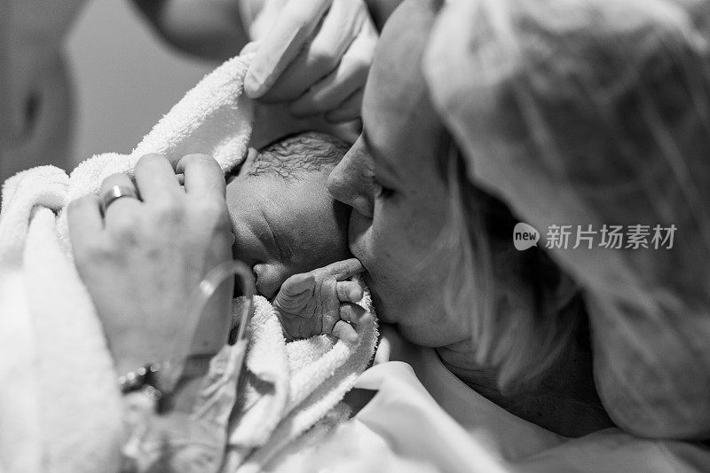 医院里，分娩后的母亲抱着刚出生的婴儿