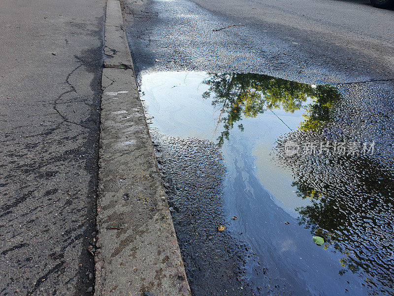 油渍，油渍:路上溅出的一滩汽油或石油产品环境污染概念