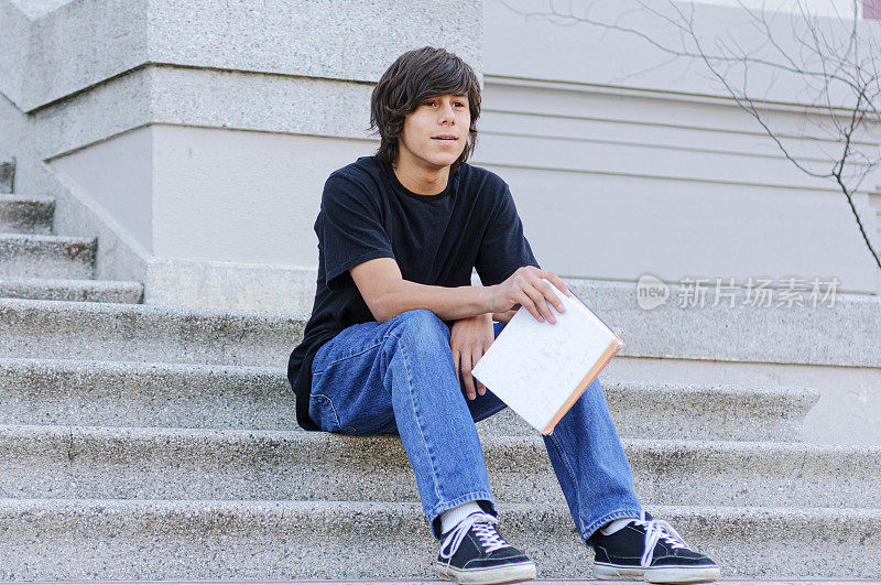拉丁裔少年在学校台阶上学习