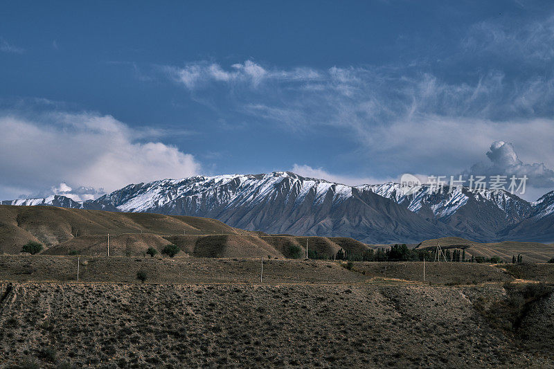 山谷和较低山脉后面的雪山山脊。南天山，贾拉拉巴德地区，吉尔吉斯斯坦