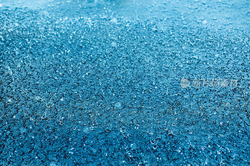 雨滴落在水坑里。下雨了。溅起的水