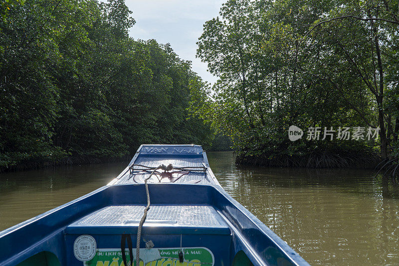 这艘复合船在湄公河三角洲嘉茂红树林的运河中央航行。