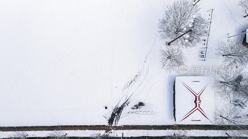 在新泽西州麦迪逊市的一个公园里，积雪覆盖的体育场的建筑上有雪脚印