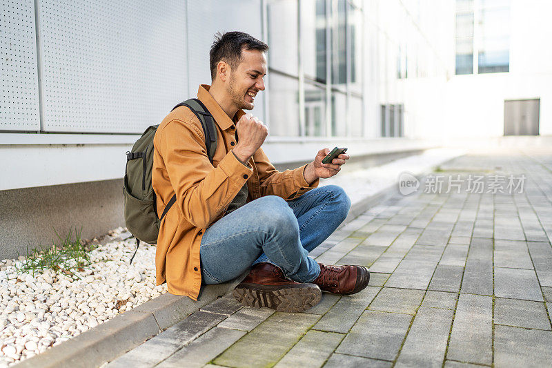 在智能手机上玩电子游戏的快乐男子