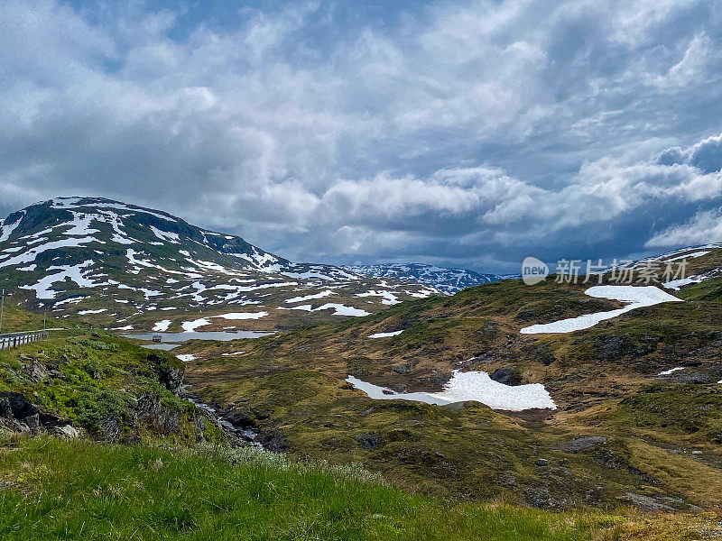 挪威的山景，雪，草和湖