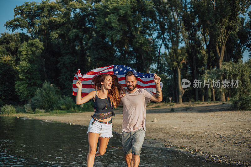 一对年轻的美国夫妇在他们的头顶上飘扬着美国国旗时陷入了爱河。
