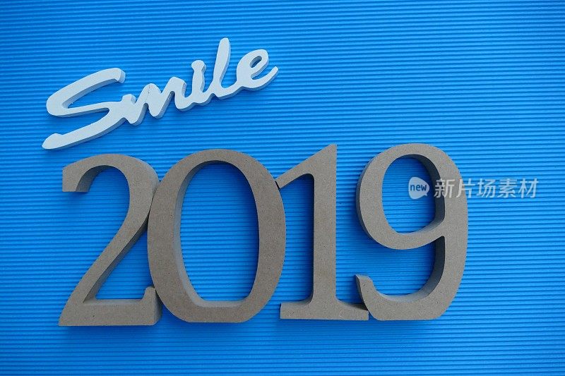蓝色条纹背景上的单字微笑和2019年