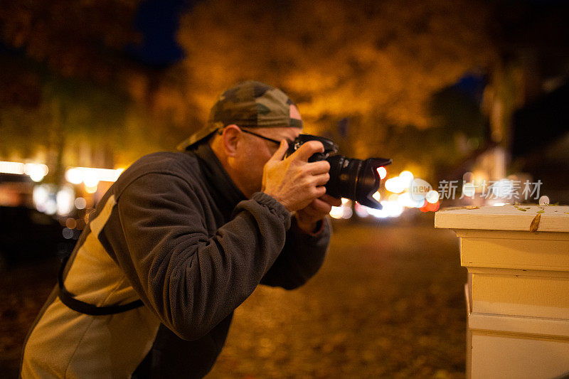 夜间城市男性街头摄影师拿着相机