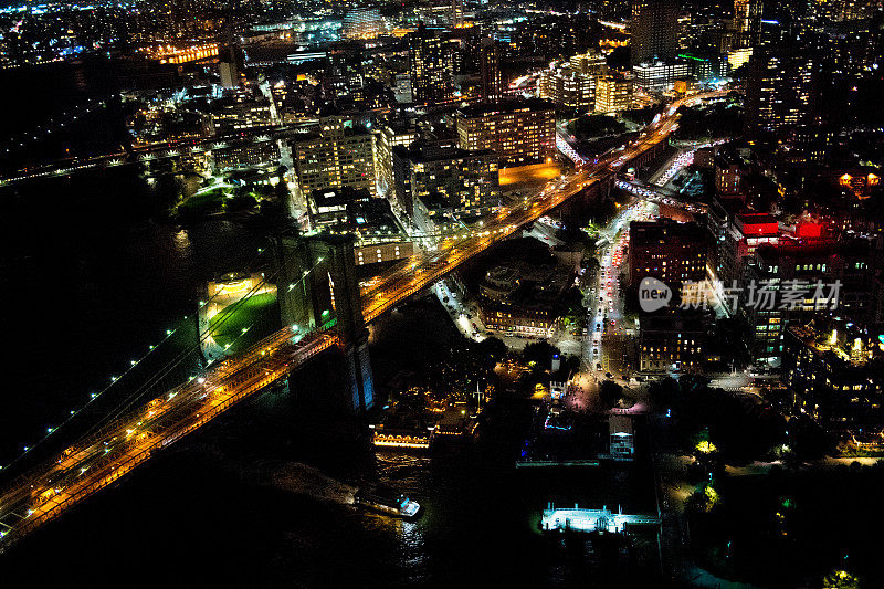 纽约布鲁克林大桥的鸟瞰图，从一架直升机在东河上方拍摄的夜晚