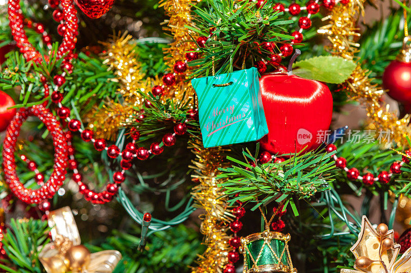 用装饰物、圣诞灯泡和各种其他装饰品装饰的圣诞树的一部分;特写镜头。