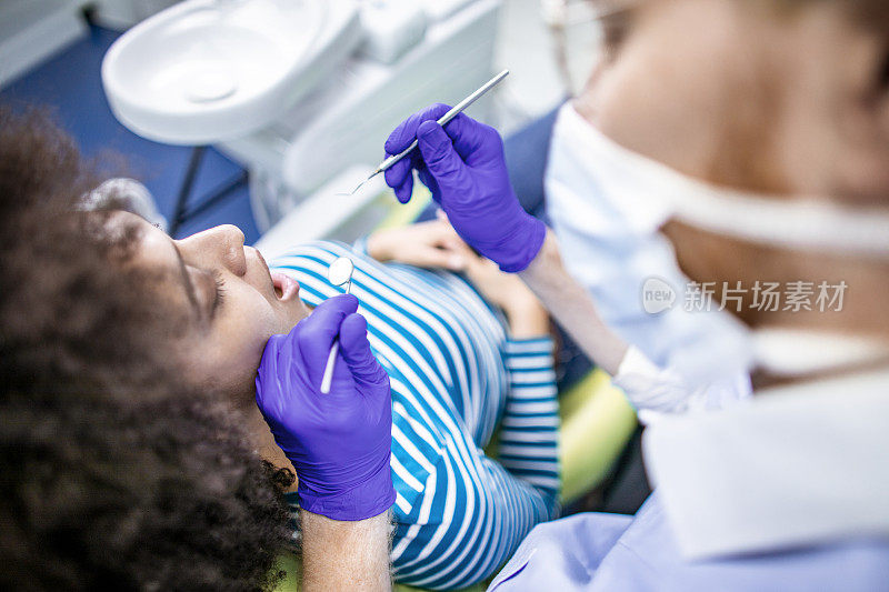 牙科检查-牙医使用挖掘机镰刀探针和口镜对病人进行牙科检查