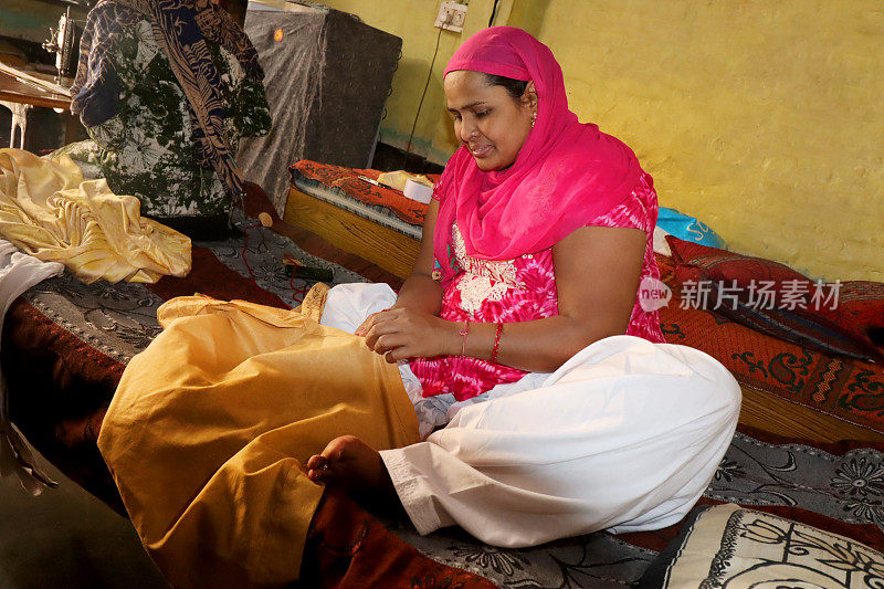 农村妇女用针缝衣服