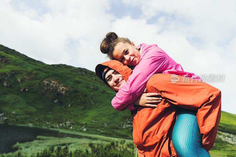 年轻夫妇在美丽的湖附近的山上玩耍