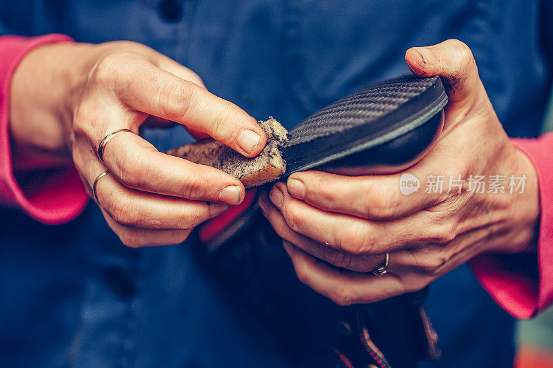 手工制鞋行业中经验丰富的补鞋匠的双手，完成鞋底。